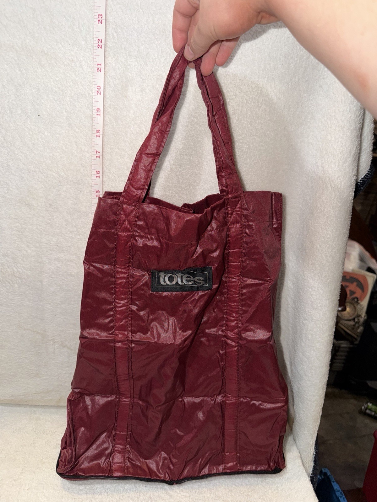 Totes Brand expandable shopping bag in a burgundy maroon color